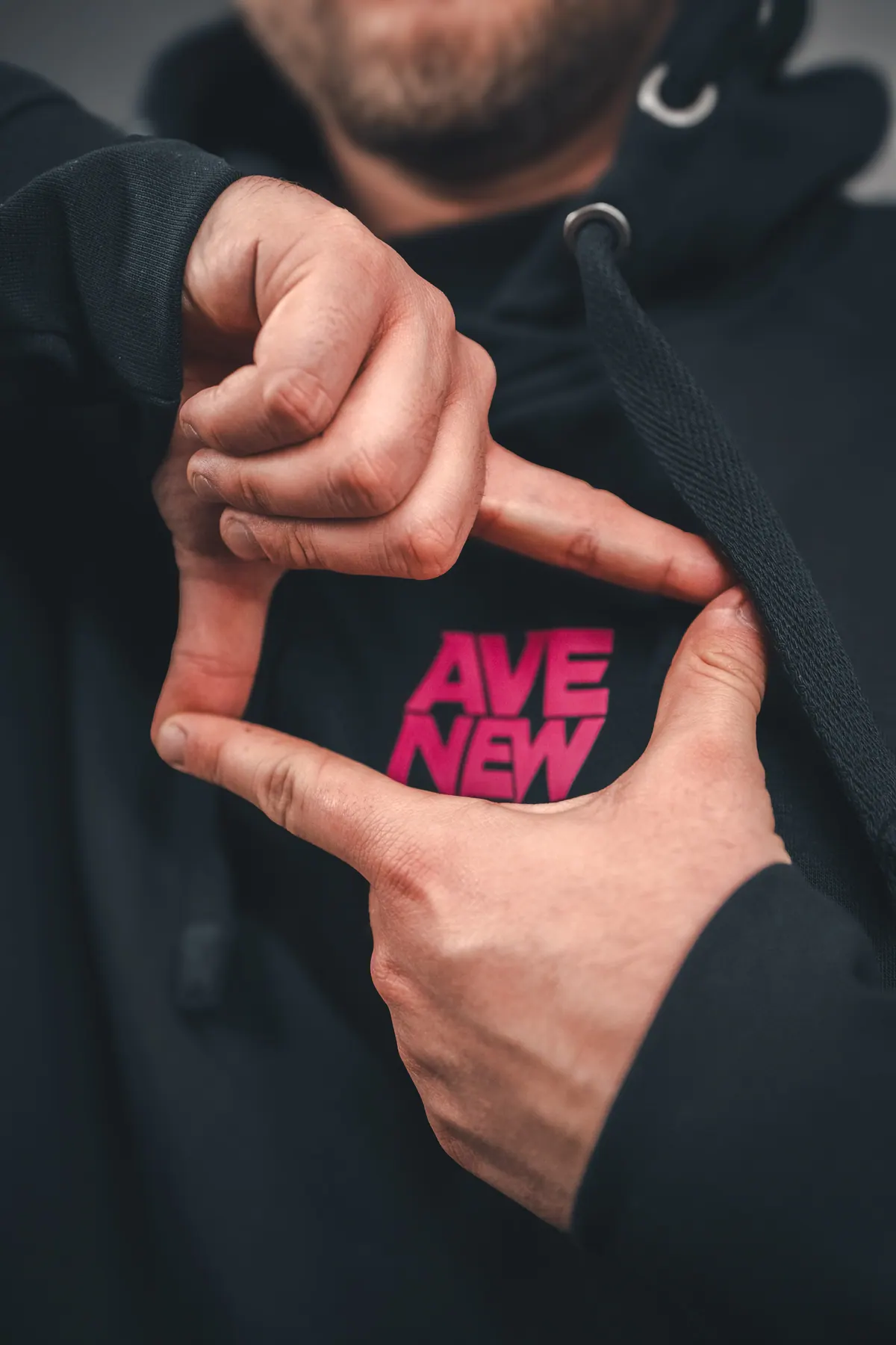 Logo AVE NEW w magencie na czarnej bluzie